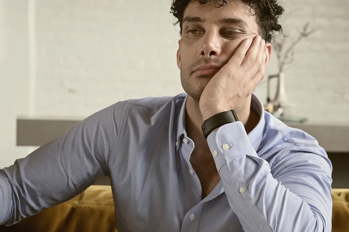 A man sitting on his own, looking away from the camera.