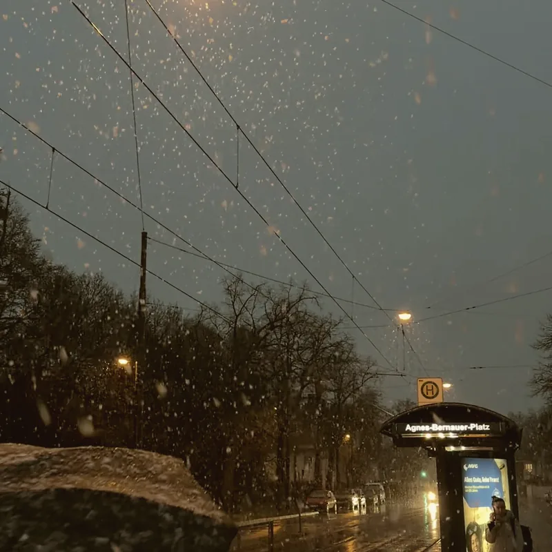 City lights through the window of a bus at night.