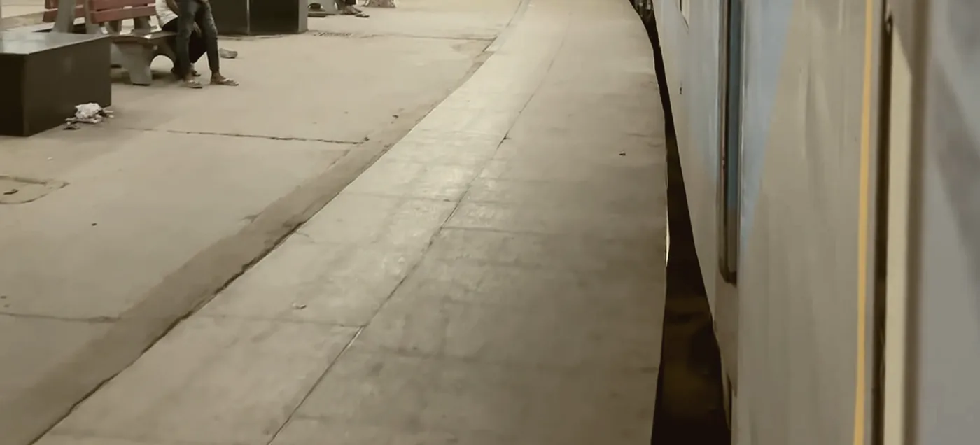 A figure alone on a station platform as a train pulls away.