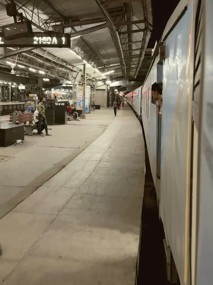 A figure alone on a station platform as a train pulls away.