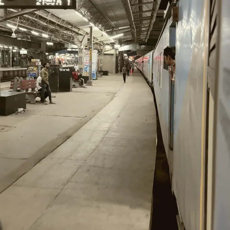 A figure alone on a station platform as a train pulls away.