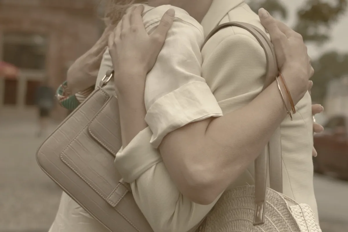 Two people saying goodbye in a doorway.