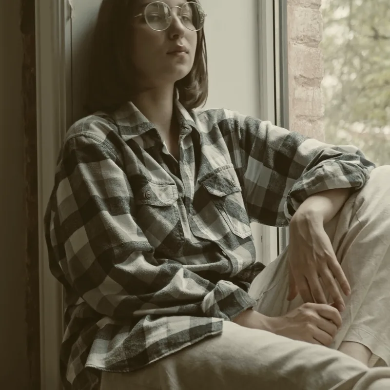 Someone looking out of a window, lost in thought.